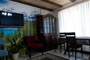 a living room with a tv and a painting on the wall at Садиба Кичера Gold in Mizhhirʼʼya