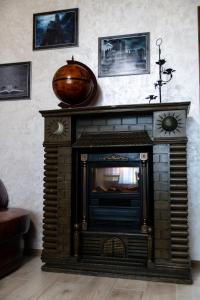 a fireplace in a living room with a vase on the wall at Садиба Кичера Gold in Mizhhirʼʼya