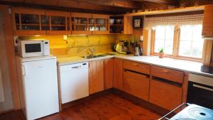 a kitchen with a white refrigerator and a microwave at Klævold utleigehytte in Klevoll