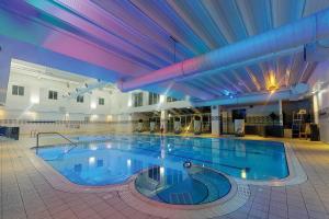 ein großer Pool in einem großen Gebäude in der Unterkunft Village Hotel Birmingham Walsall in Walsall