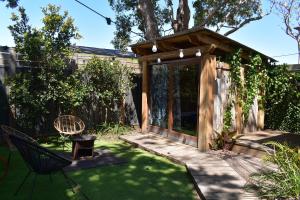 a garden with a wooden pergola and a green yard at Discover Bali in Booker Bay in Booker Bay