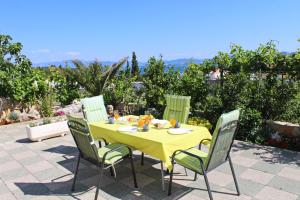 a yellow table and chairs with a yellow table and chairs at Apartments Gusti in Drače