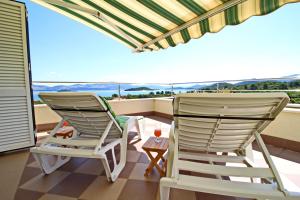 two chairs on a balcony with a view of the ocean at Apartments Gusti in Drače