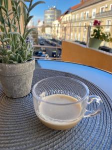 a glass cup of coffee sitting on a table at Katy Boulevard Apartman in Satu Mare