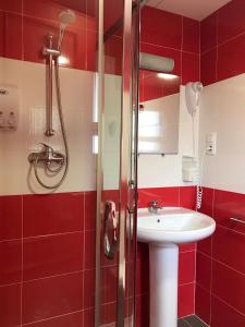 a red bathroom with a sink and a shower at Mana Mana Youth Hostel in Tossa de Mar
