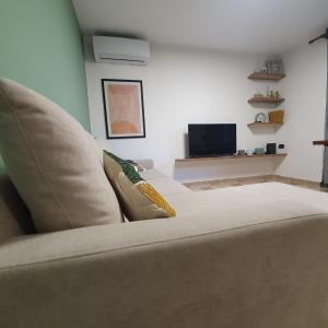 uma sala de estar com um sofá e uma televisão em Central Home Away From Home em Shkodër