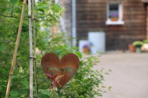 Ein Herzschild hängt von einem Busch im Garten in der Unterkunft fewos am kleinen meer in Waren (Müritz)