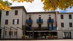 a large white building with blue balconies at Albergo Ristorante Plaza in Tornolo