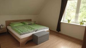 a bedroom with a bed with green sheets and a window at FeWo2 Griese in Damnatz