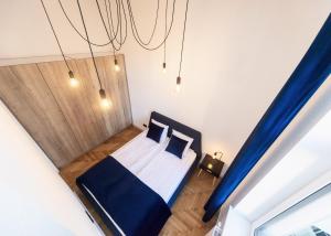 a small bedroom with a bed and blue curtains at Studio Matejki C in Bielsko-Biała