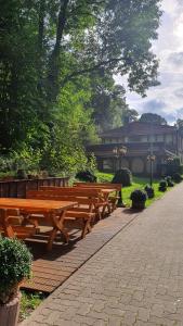 una fila di panche di legno in un parco di Hotel Harzlodge a Goslar