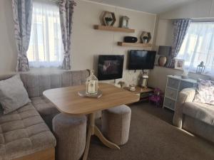 a living room with a table and a couch at The orchards holiday home in Clacton-on-Sea