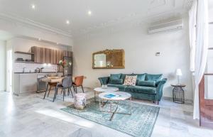 een woonkamer met een groene bank en een tafel bij Los Corceles Casa Palacio in Jerez de la Frontera
