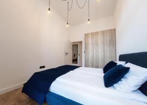 ein Schlafzimmer mit einem großen Bett mit blauen und weißen Kissen in der Unterkunft Apartament Matejki E in Bielsko-Biała