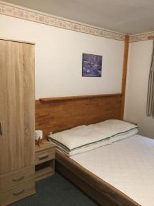 een slaapkamer met een bed en een houten hoofdeinde bij Chalupa Horní Lánov in Dolni Dvur