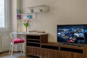 sala de estar con TV, escritorio y mesa en PrimoPiano - Ariberto, en Milán
