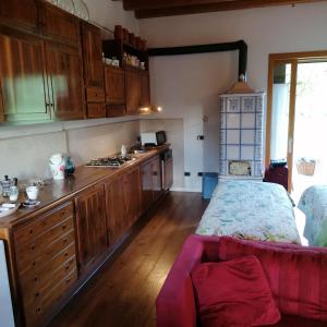 eine Küche mit Holzschränken und ein Bett in einem Zimmer in der Unterkunft Locazione turistica la casetta in Conegliano