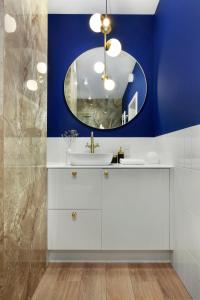 a bathroom with a sink and a mirror at Elite Apartments Granaria The View in Gdańsk