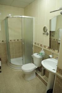 a bathroom with a toilet and a shower and a sink at Hotel BEK in Tashkent