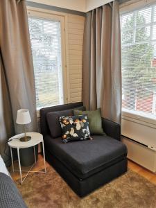 a black couch in a room with a window at Luulampi - Studio in the center of Saariselkä in Saariselka