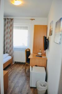 um pequeno quarto com uma secretária e uma cama em Hotel Discovery em Stuttgart