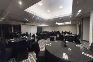 a conference room with tables and chairs and a room with tables and chairsktop at Village Hotel Birmingham Walsall in Walsall