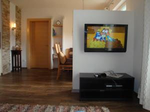 瑙德斯的住宿－Aida Apart，客厅设有壁挂式平面电视。