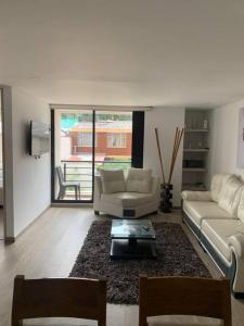 un soggiorno con divano e tavolo di Cómodo y hermoso apartamento para renta. a Bogotá