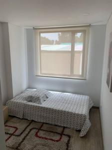 a bedroom with a bed in front of a window at Cómodo y hermoso apartamento para renta. in Bogotá