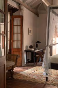 a bedroom with a bed and a table and a desk at The Fort Printers in Galle