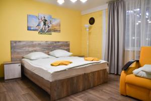 a bedroom with a bed and a yellow wall at Наша Арена in Yoshkar-Ola