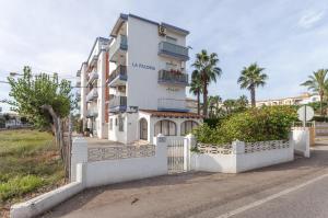 a white building with a fence in front of it at Palomas in Denia