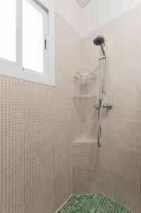 a shower in a tiled bathroom with a window at Palomas in Denia +14 photos