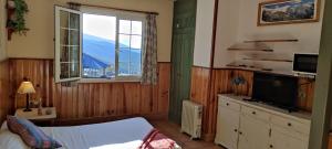 a bedroom with a bed and a window and a television at Estudio Edificio Salvia zona remontes in Sierra Nevada