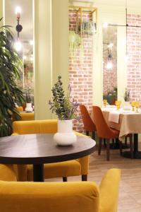 a dining room with a table and yellow chairs at AMAKS Premier Hotel in Perm