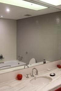 La salle de bains est pourvue d'un lavabo et d'un grand miroir. dans l'établissement 26° South Bush Boho Hotel, à Muldersdrift
