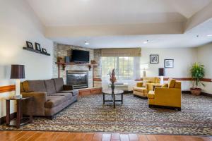 sala de estar con sofás y chimenea en Sleep Inn & Suites, en Grand Rapids