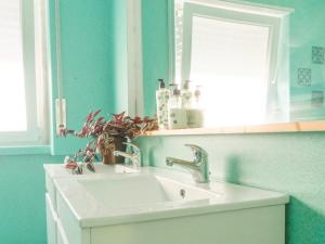 a white sink in a bathroom with a mirror at Hospedium Hostel República Surf House in Ericeira