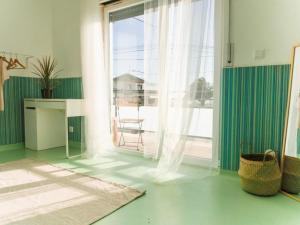 a living room with a large window and a table at Hospedium Hostel República Surf House in Ericeira