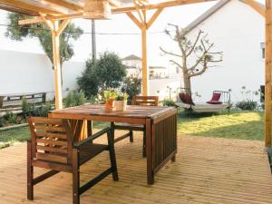 a wooden table and chairs on a wooden deck at Hospedium Hostel República Surf House in Ericeira