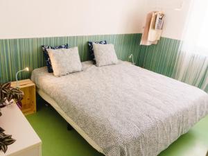 a bed in a room with a green wall at Hospedium Hostel República Surf House in Ericeira