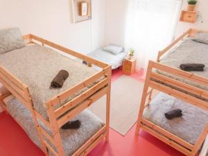 two bunk beds in a room with shoes on the floor at Hospedium Hostel República Surf House in Ericeira