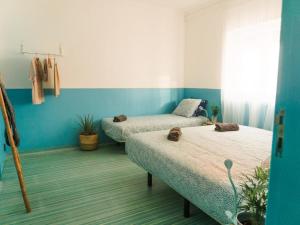 2 Betten in einem Zimmer mit blauen Wänden in der Unterkunft Hospedium Hostel República Surf House in Ericeira