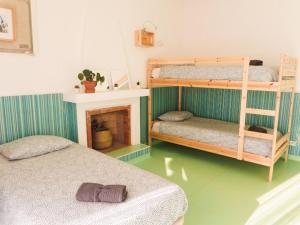 a bedroom with two bunk beds and a fireplace at Hospedium Hostel República Surf House in Ericeira