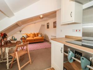 a kitchen and a living room with a couch at Flat 6 - 5 High East Street in Dorchester