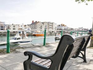 a bench sitting next to a body of water with boats at Flat 6 - 5 High East Street in Dorchester
