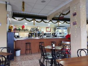 een restaurant met tafels en stoelen en een bar bij Alcalá del rio! bajo B in Alcalá del Río