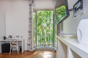 uma casa de banho com uma porta de vidro deslizante que leva a uma varanda em IHH Suites Rome em Roma