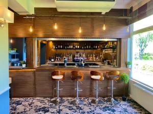 a bar with brown stools in a room at Anchorage Hotel & Spa in Torquay