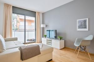 Inside Barcelona Apartments Princep في برشلونة: غرفة معيشة مع أريكة بيضاء ونافذة